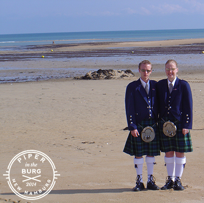 Couple in kilted uniform standing on beach